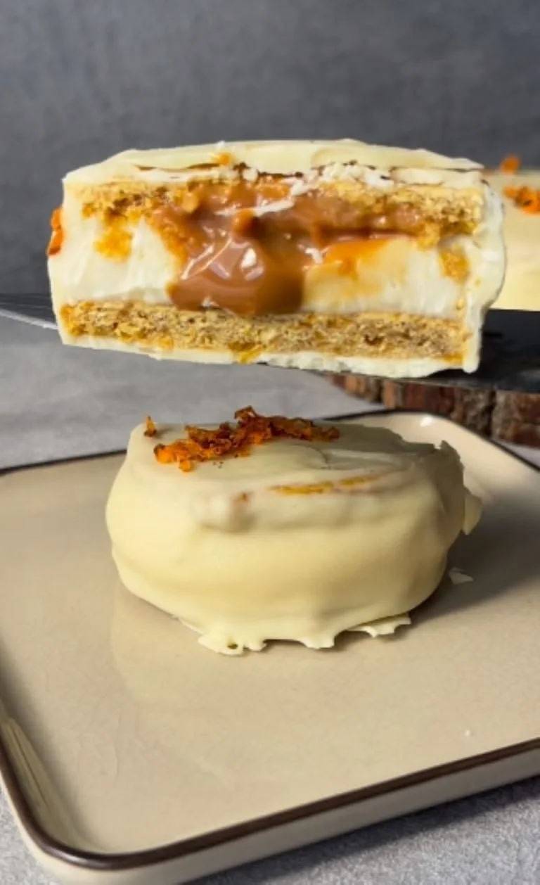 Alfajor con baño de chocolate blanco y relleno de dulce de leche